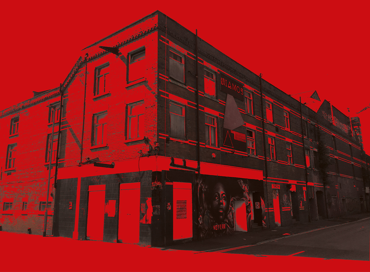 Red washed image of a street corner in Manchester.